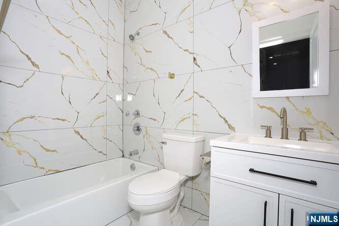 385 Passaic Avenue, Unit 6 Lodi, NJ 07644 - Photo 18 of 23 a bathroom with a sink toilet vanity and tub