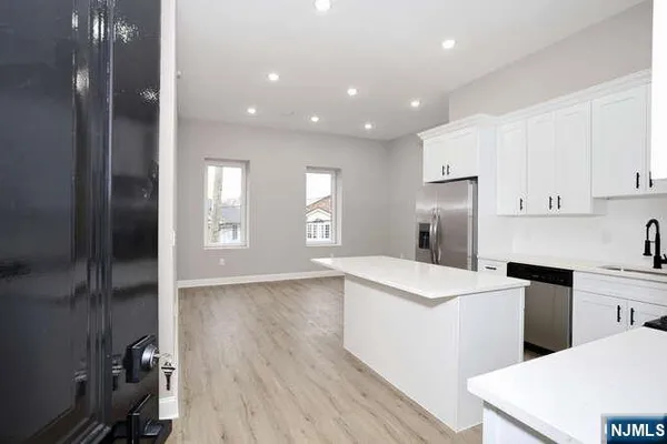 a kitchen with a refrigerator and a stove top oven