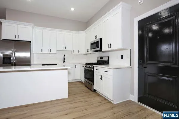a kitchen with black cabinets and appliances