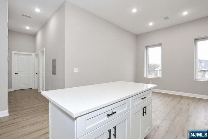385 Passaic Avenue, Unit 6 Lodi, NJ 07644 - Photo 6 of 23 a room with a wooden floor and white cabinets