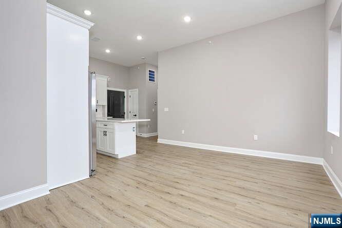 385 Passaic Avenue, Unit 6 Lodi, NJ 07644 - Photo 9 of 23 a view of a kitchen with a sink and dishwasher with wooden floor