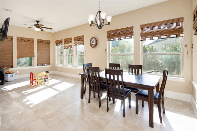 a dining room with wooden floor a chandelier a wooden table and chairs