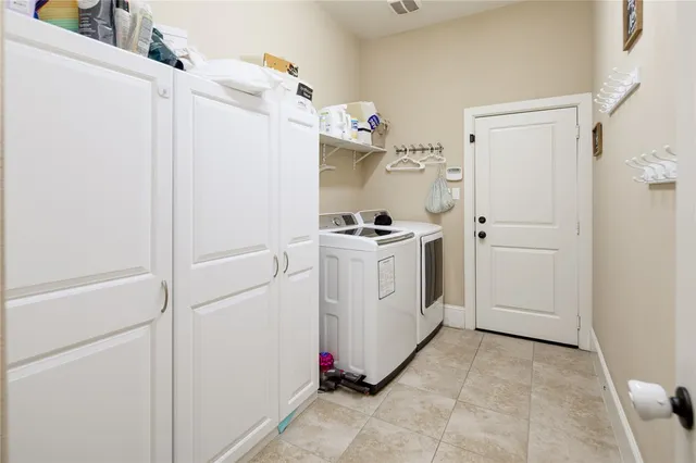 a utility room with cabinets washer and dryer