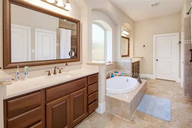 a bathroom with a sink vanity tub and a mirror