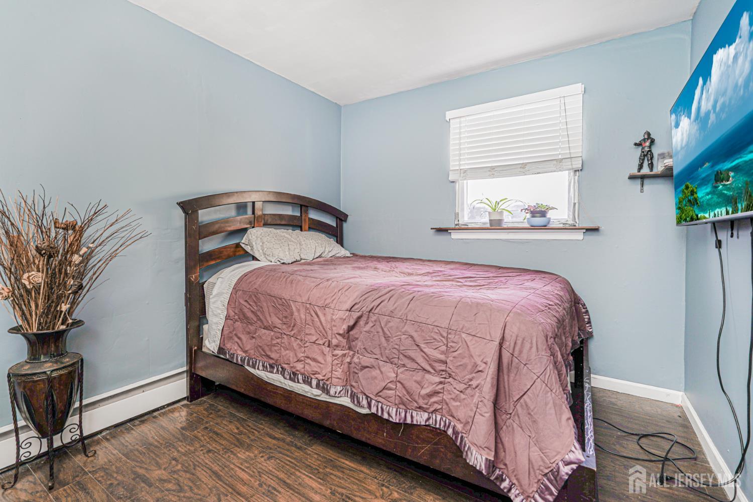 7 Walnut Lane Parlin, NJ 08859 - Photo 18 of 22 a bedroom with a bed lamp and a potted plant on the dresser