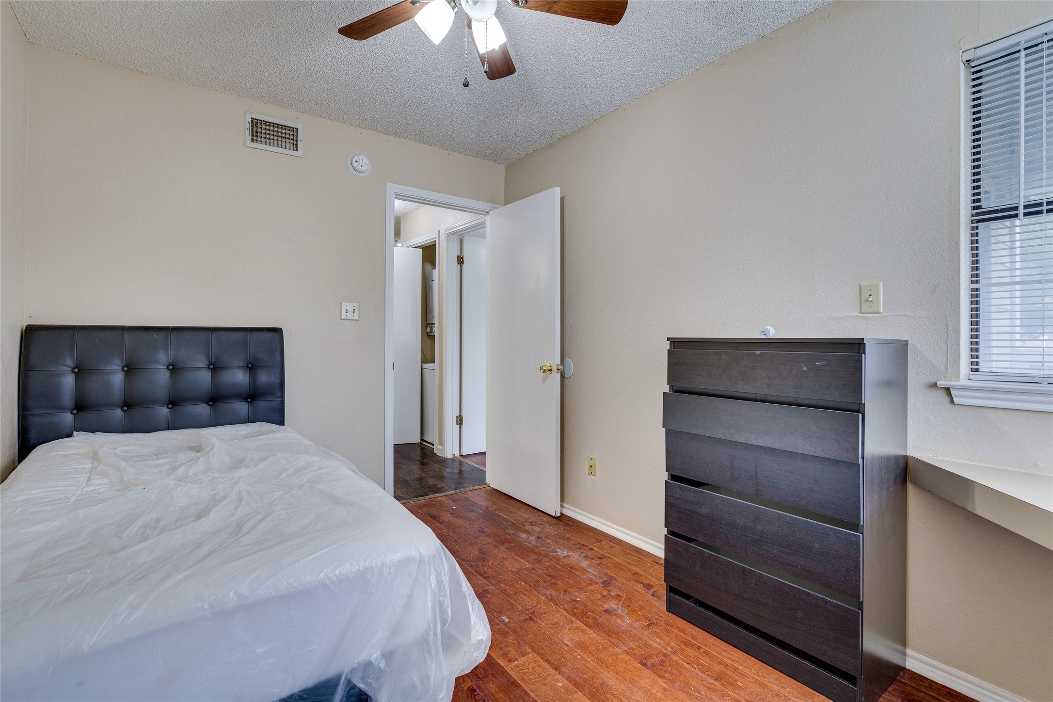 1808 Rio Grande Street, Unit 6 Austin, TX 78701 - Photo 24 of 29 Bedroom featuring a textured ceiling, dark wood-style floors, and ceiling fan