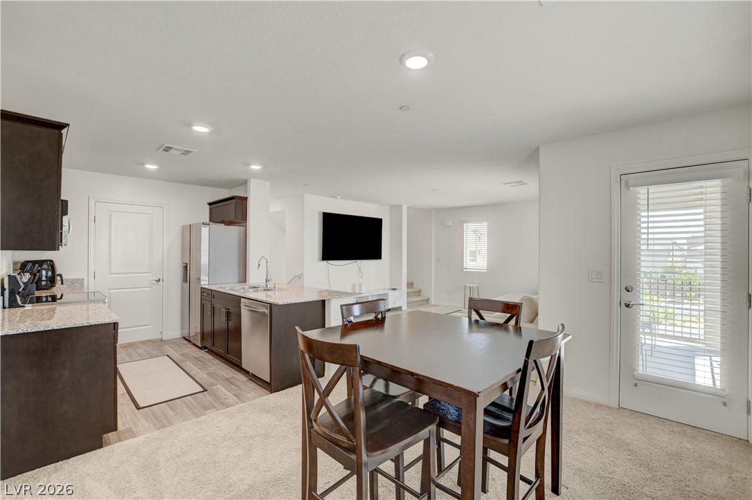 6924 Spicy Merlot Street North Las Vegas, NV 89086 - Photo 12 of 83 An inviting open-concept area integrates the kitchen and dining spaces for seamless entertaining.