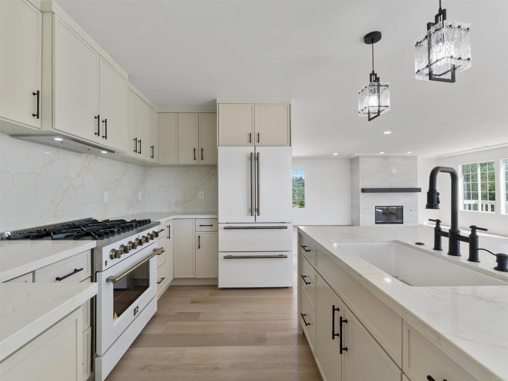 28148 Mountain Meadow Road Escondido, CA 92026 - Photo 20 of 51 a kitchen with granite countertop white cabinets and white appliances