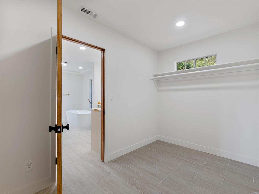 28148 Mountain Meadow Road Escondido, CA 92026 - Photo 29 of 51 an empty room with wooden floor and mirror
