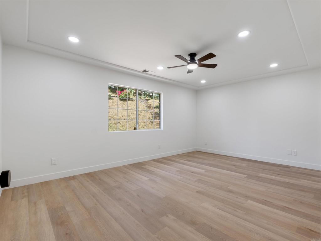 28148 Mountain Meadow Road Escondido, CA 92026 - Photo 30 of 51 an empty room with chandelier fan and windows