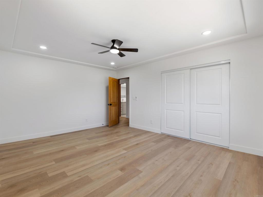 28148 Mountain Meadow Road Escondido, CA 92026 - Photo 33 of 51 a view of an empty room with wooden floor and a ceiling fan