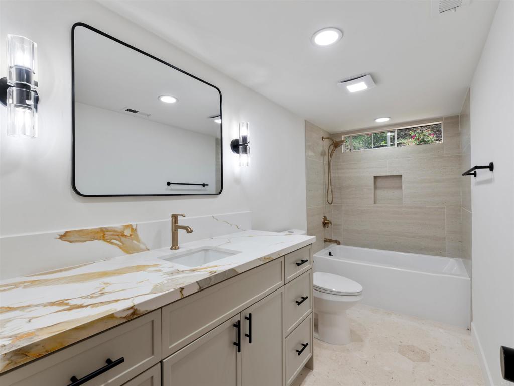 28148 Mountain Meadow Road Escondido, CA 92026 - Photo 34 of 51 a bathroom with a granite countertop sink a toilet a mirror and shower