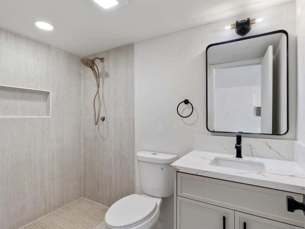 28148 Mountain Meadow Road Escondido, CA 92026 - Photo 40 of 51 a bathroom with a toilet sink vanity and mirror