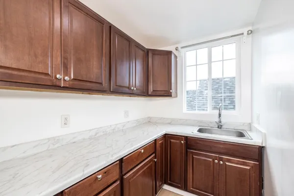 a kitchen with stainless steel appliances granite countertop wooden cabinets a sink and a window