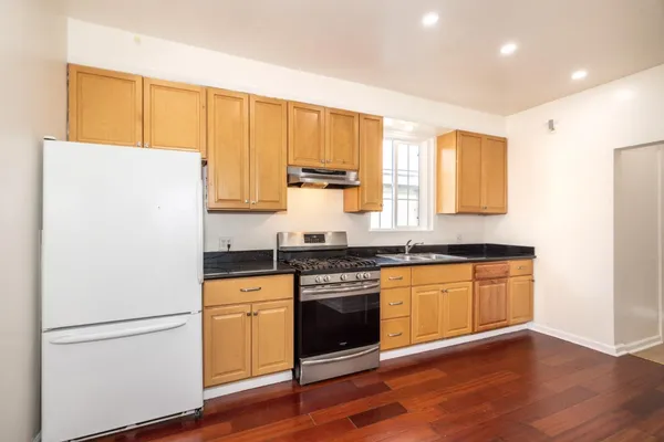 a kitchen with granite countertop white cabinets and white appliances