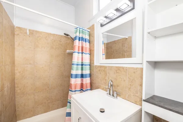 a bathroom with a sink a mirror and a shower