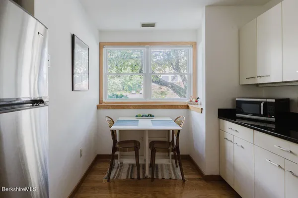 a kitchen with stainless steel appliances granite countertop sink microwave and white cabinets