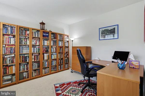 a view of a workspace with furniture and book shelf