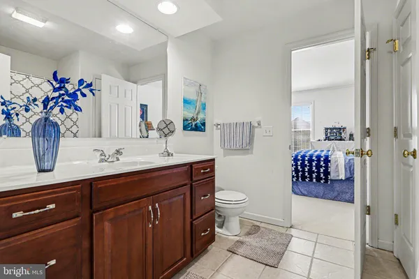 a bathroom with a double vanity sink mirror and toilet
