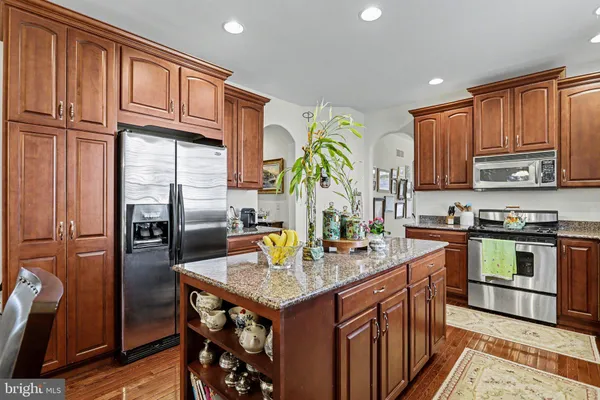 a kitchen with stainless steel appliances granite countertop a refrigerator a stove and a sink