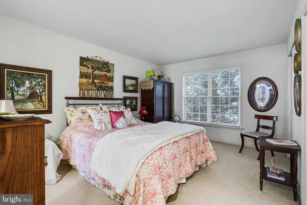 a bedroom with bed and a large mirror on a dresser