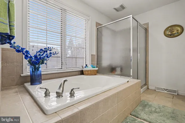 a bath tub sitting in a bathroom next to a shower