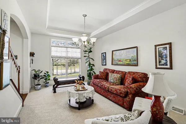 a living room with furniture and a chandelier
