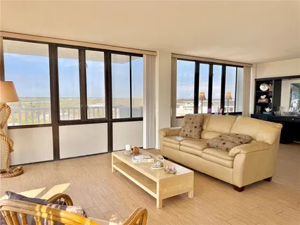 a living room with furniture a flat screen tv and a large window