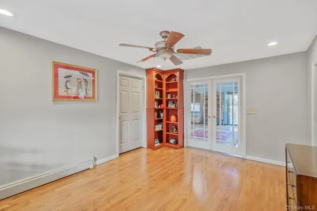 a view of an empty room with a window and a chandelier fan