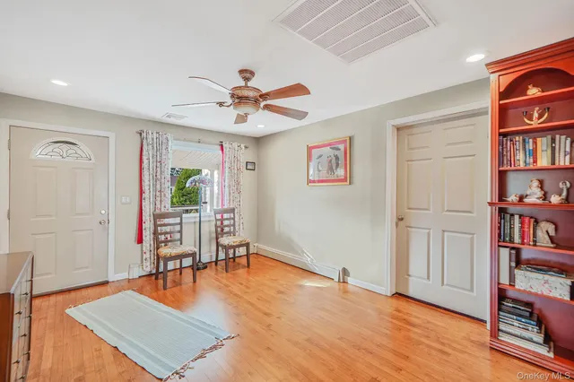 a living room with furniture a bookshelf and a window