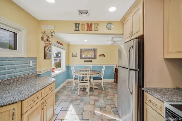 a kitchen with stainless steel appliances granite countertop a refrigerator and a stove top oven