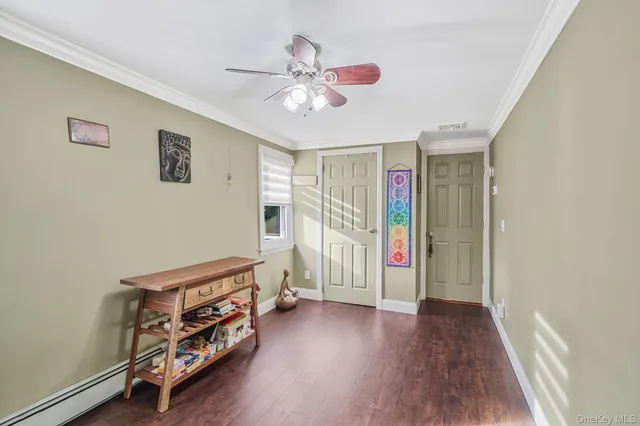 a view of a room with wooden floor and ceiling fan