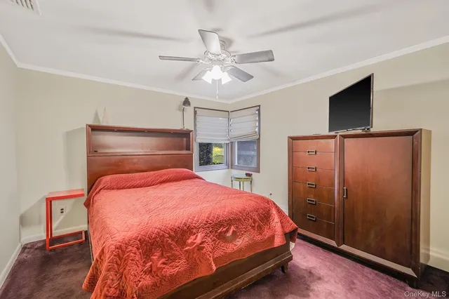 a bedroom with a bed and a flat tv screen on dresser
