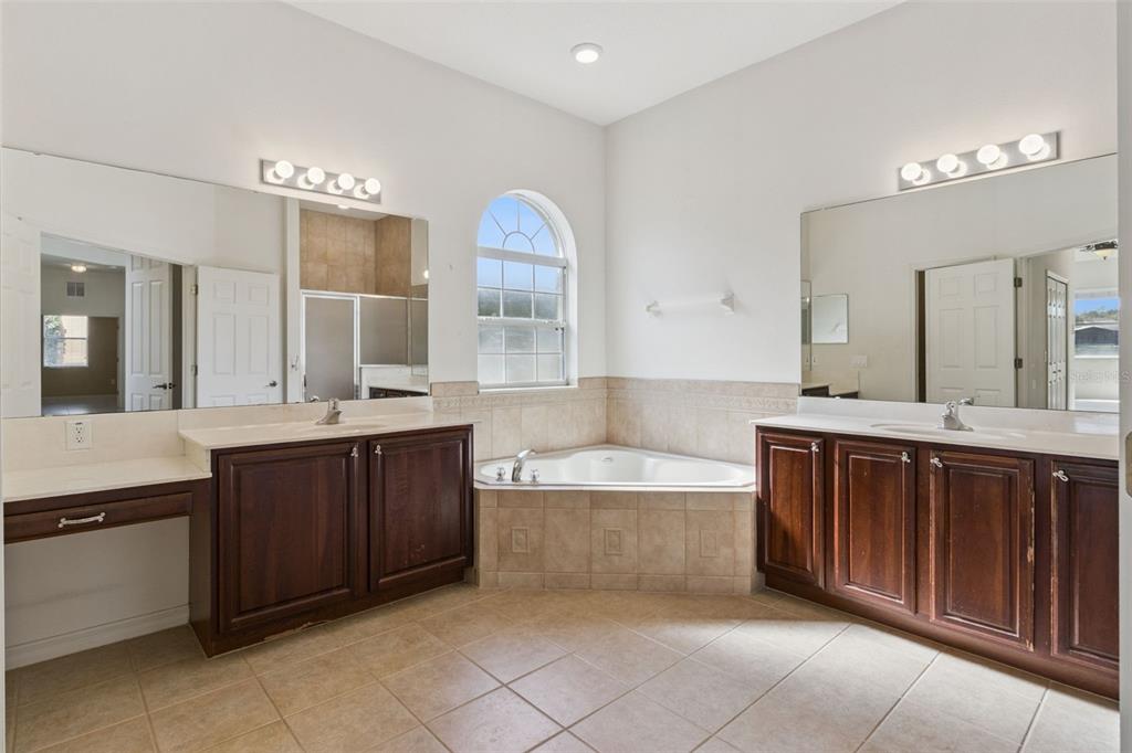 3643 Peaceful Valley Drive Clermont, FL 34711 - Photo 13 of 52 a spacious bathroom with a tub a double vanity sink and mirror