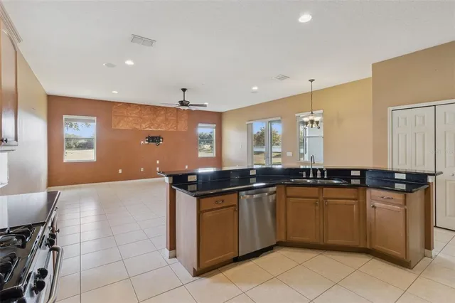 a kitchen with stainless steel appliances granite countertop a stove a sink and a refrigerator