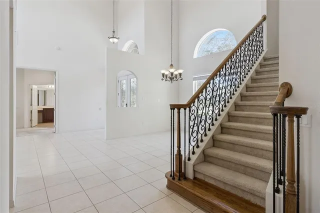 a view of a hallway with chandelier and glass door