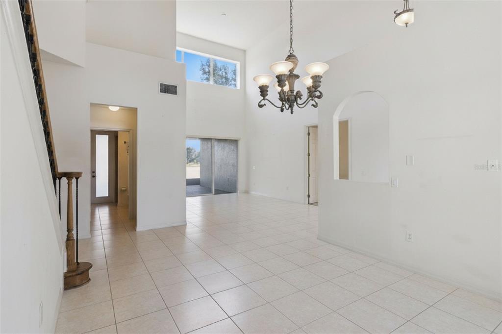 3643 Peaceful Valley Drive Clermont, FL 34711 - Photo 6 of 52 a view of a hallway with chandelier and glass door