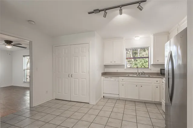 a kitchen with white cabinets and white appliances