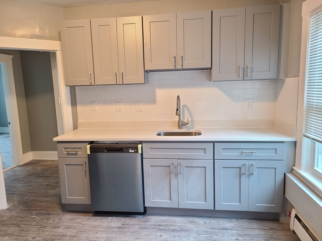 64 Stockton Street Boston, MA 02124 - Photo 14 of 27 a kitchen with stainless steel appliances granite countertop a sink and a white cabinets