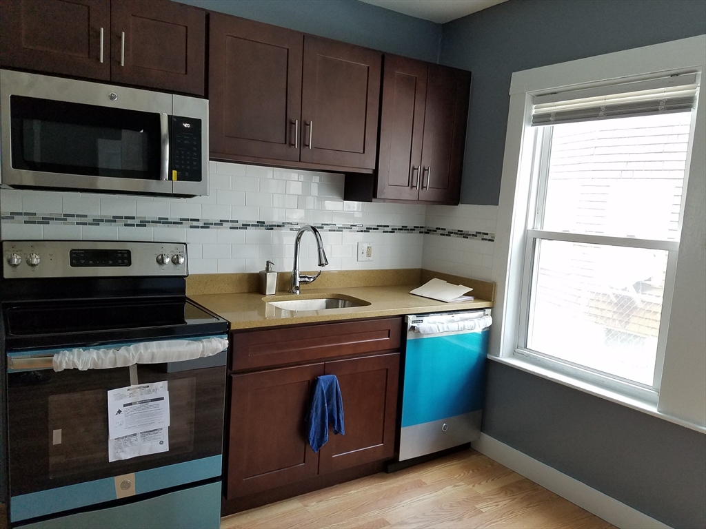 64 Stockton Street Boston, MA 02124 - Photo 16 of 27 a kitchen with a stove microwave and sink