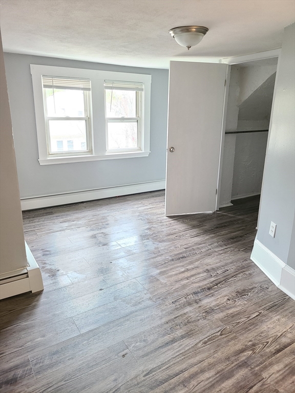 64 Stockton Street Boston, MA 02124 - Photo 3 of 27 an empty room with wooden floor and windows