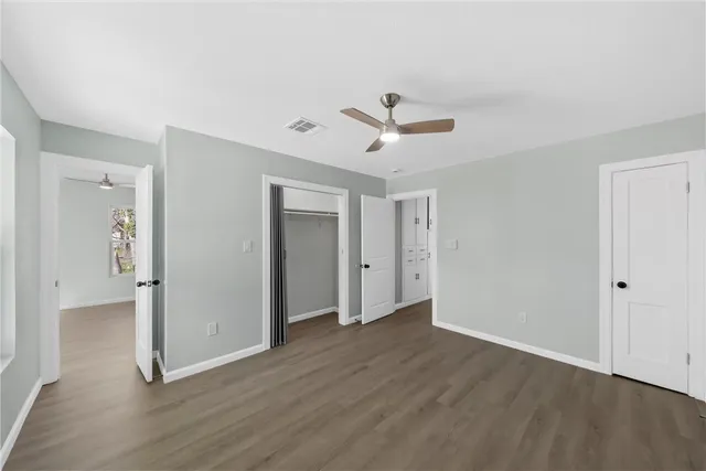 a view of a room with wooden floor and ceiling fan