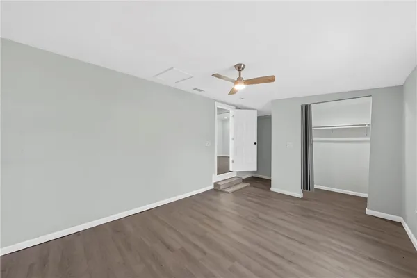 a view of an empty room with window and wooden floor