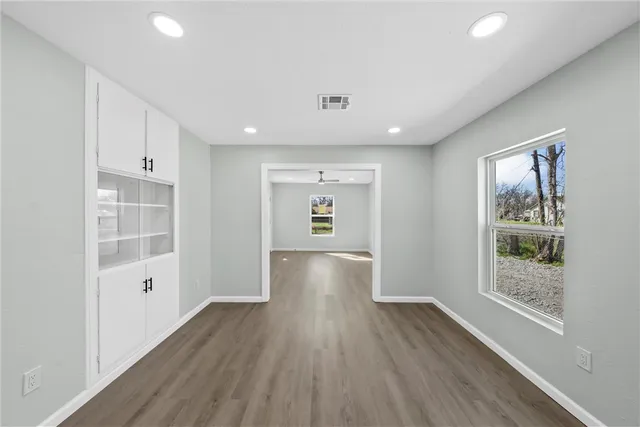 a view of a room with wooden floors and windows