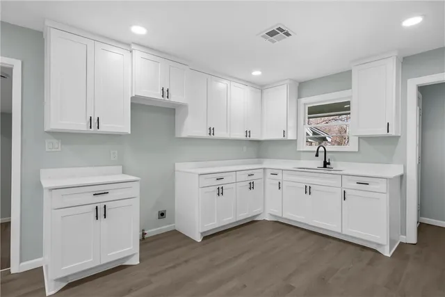 a kitchen with white cabinets stainless steel appliances and sink