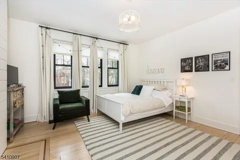 a bedroom with a bed couch and a window