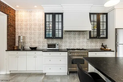a kitchen with granite countertop white cabinets and white appliances