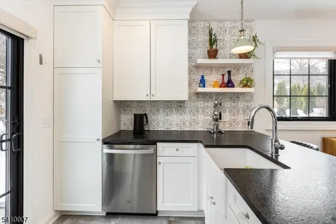 a kitchen with stainless steel appliances granite countertop a sink stove and cabinets