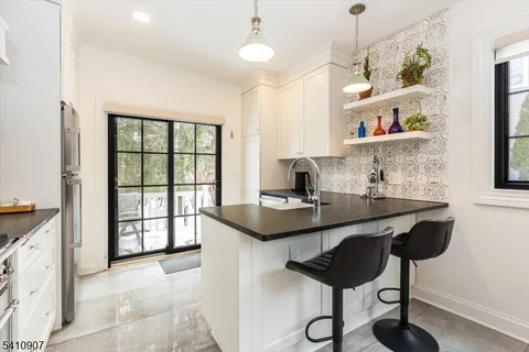 a kitchen with stainless steel appliances granite countertop a sink a stove and a refrigerator