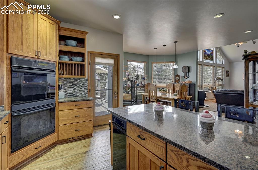5910 McCart Ranch Circle Elizabeth, CO 80107 - Photo 9 of 50 a kitchen with stainless steel appliances granite countertop a lot of counter space and wooden floor